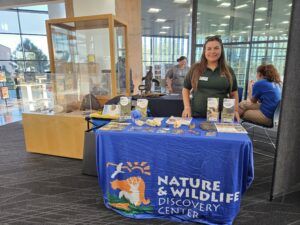 Elise standing at outreach table